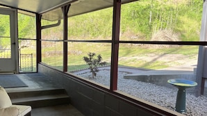 A covered patio area with a seating arrangement, a small plant, and a birdbath. - Minutes from the Illinois River, Welcome to Native Springs! (Tahlequah)