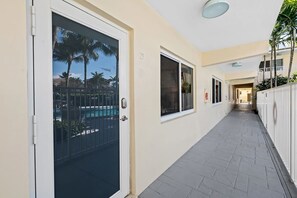 A corridor with a pool view, a door, and a window. - Bermuda Isles Villas - King #23 (Lauderdale-by-the-Sea)