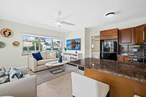 A modern kitchen with granite countertops, wooden cabinets, and a stainless steel refrigerator.