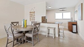 Une cuisine moderne dotée d’un îlot central, de meubles blancs et d’une fenêtre qui laisse entrer la lumière naturelle.