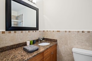 A bathroom with a sink, mirror, and toilet.