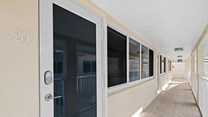Ein Korridor mit Türen, die mit der Nummer 20 gekennzeichnet sind, der zu einzelnen Zimmern mit vergitterten Fenstern führt.
