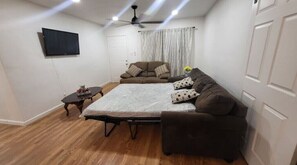 Cozy living space with a sofa, side table, and flat-screen TV.