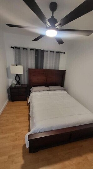 Cozy retreat with a single bed, nightstand, and cabinet, featuring a ceiling fan and ceiling light.