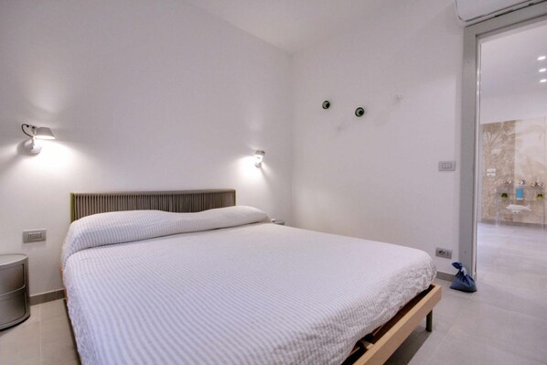 Cozy retreat with a single bed, wall-mounted lights, and a clean, minimalist design.