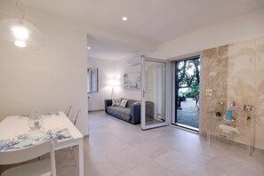 Relax in this stylish living area with a dining table, comfortable sofa, and glass coffee table.