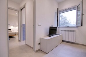 Enjoy a comfortable stay in this stylish room featuring a bench, flat-screen TV, and radiator for a cozy atmosphere.