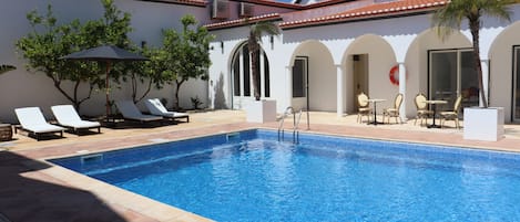 Utomhuspool, parasoller och solstolar