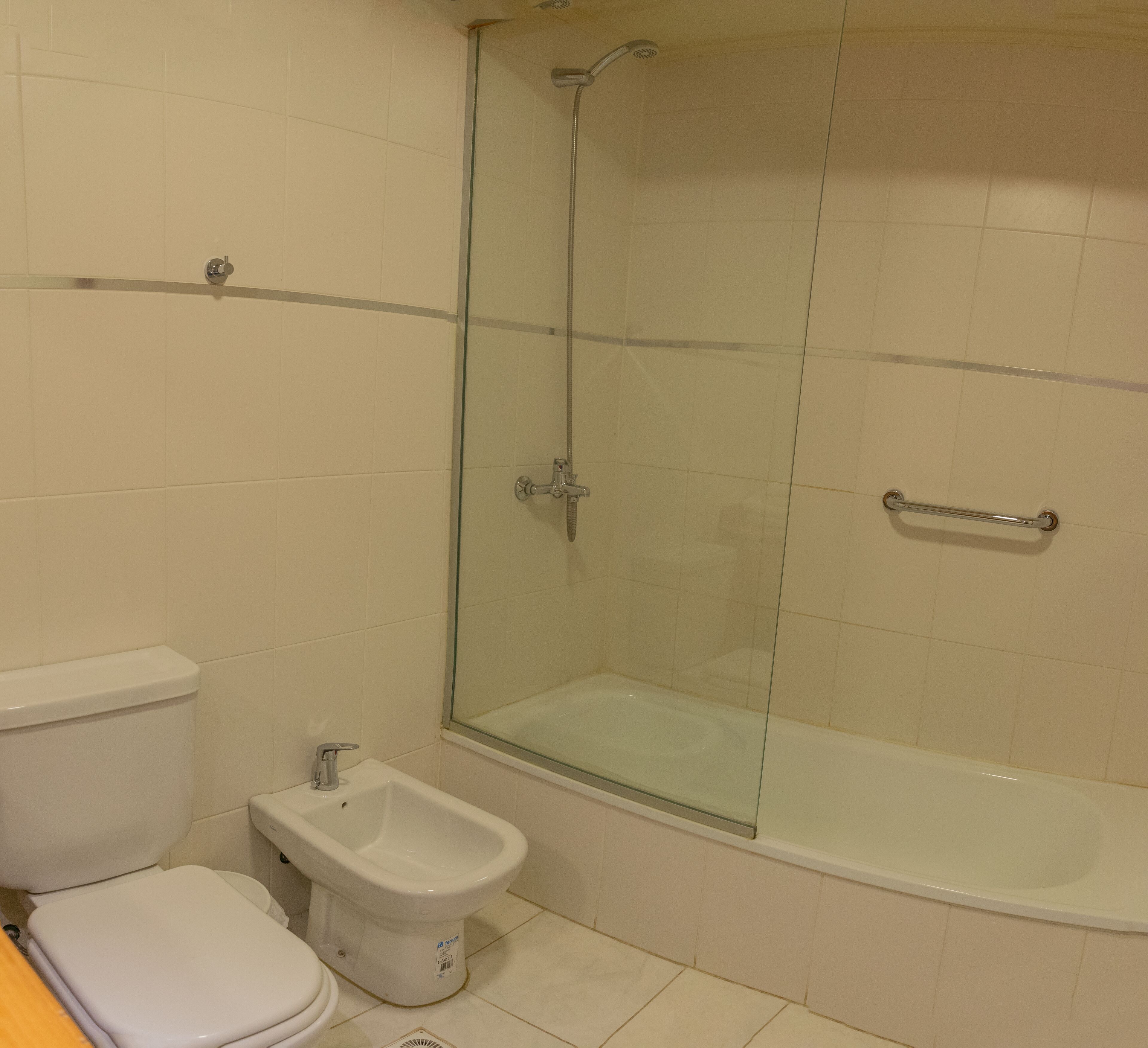 A bathroom with a glass-enclosed shower, a toilet, and a bidet.
