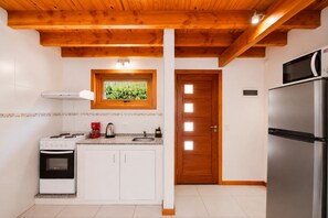 A kitchen with a stove, oven, sink, and a refrigerator.
