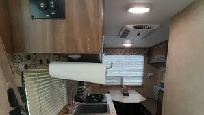A compact kitchen with a sink, stove, and a small refrigerator. - Lake House (Beechgrove)