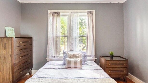 A bedroom with a bed, a dresser, and a nightstand. - Historical Blvd. Cheney Bros HillTop Mansion (Manchester)