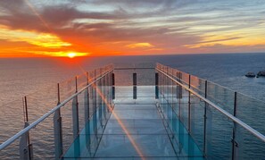 A glass bridge leading to a sunset over the ocean. - Gaviotas (Mazatlán)