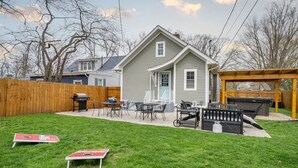 Un jardin à l’arrière d’une maison, avec une maison, des meubles d’extérieur, un barbecue et une terrasse en bois.