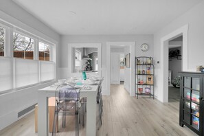 A spacious kitchen with a central island, a dining area with chairs, and a pantry with shelves.