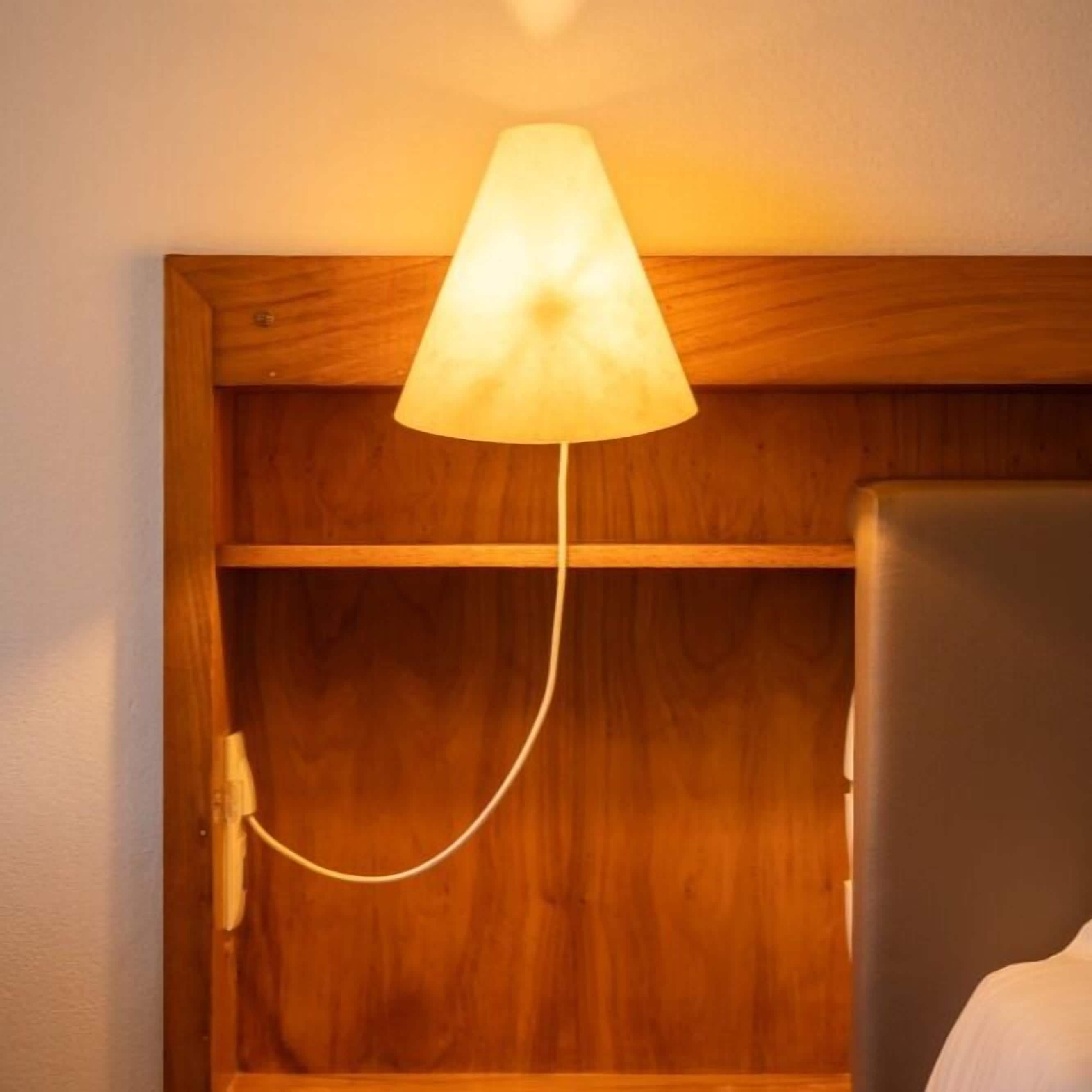 Cabecera de madera con una lámpara colgante.
