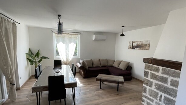 A modern living room with a dining table, a sofa, and a stone fireplace. - Belle Maison Rénovée Avec Jardin, à 500m du Centre Village (Goudargues)