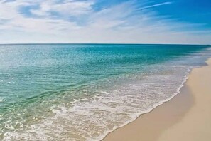 A beach with clear turquoise water and a sandy shore.