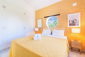 A hotel room with a bed, a nightstand, a window with a view, and a wardrobe.