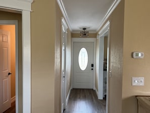 Enter a cozy space through this door, featuring a thermostat and light switch.