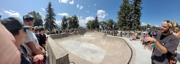 Un parc à skate doté d’une piste en béton en forme de bol et de gradins pour les spectateurs.
