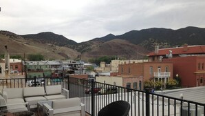 A rooftop terrace with outdoor furniture, a view of a town, and mountains in the background. - 2nd story condo overlooking the F Street Pedestrian mall, downtown Salida! (Salida)