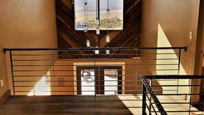 Un intérieur moderne avec un mur en bois et une grande fenêtre donnant sur un paysage.