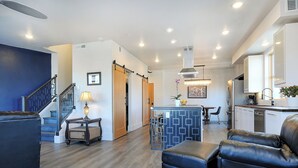A modern living room with a staircase, a dining area, and a kitchen. - 2 story condo w/ balconies, hovering above the action of the downtown scene. (Salida)