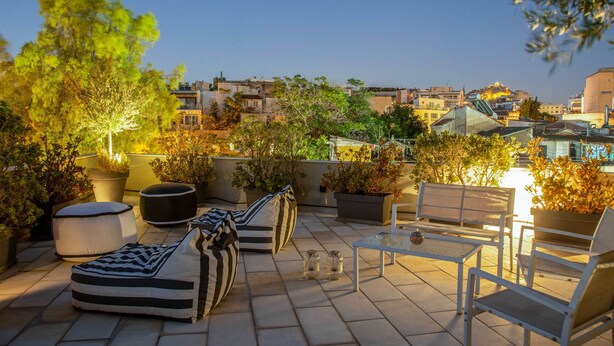 A rooftop terrace with outdoor seating, potted plants, and a view of the cityscape. - 85 sqm  in the Heart of Athens w/Rooftop Deck (Athens)