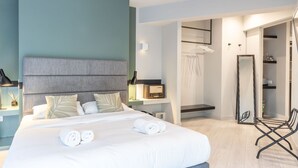 A modern hotel room with a large bed, a bedside table with a lamp, a radio, and a mirror. - Fantastic Central Athens Suite with Rooftop Deck (Athens)