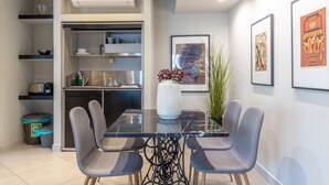 A modern kitchen with built-in appliances, a dining area with a marble table and grey chairs, and artwork on the walls. - Superb Central Athens Suite with Rooftop – Perfect for 5 Guests, 85sqm (Athens)