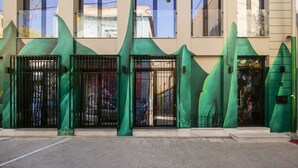 A building facade with large windows and a green awning. - Superb Central Athens Suite with Rooftop – Perfect for 5 Guests, 85sqm (Athens)