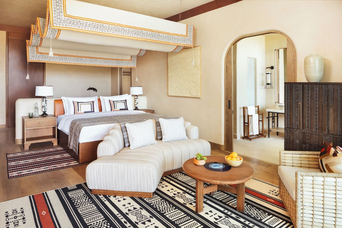 Relax in a spacious room with a large bed, seating area, and natural ambiance.