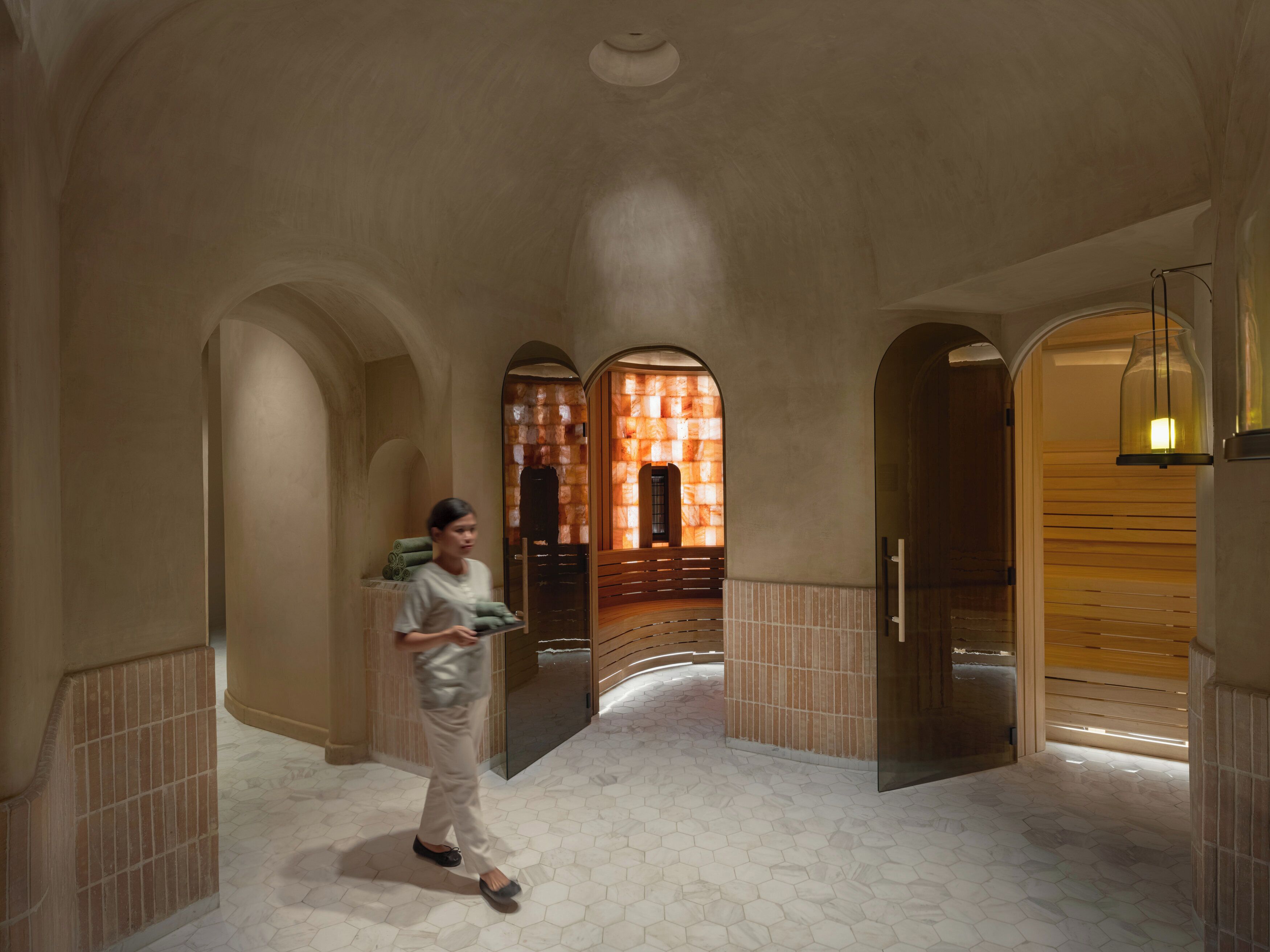 A hallway with arched ceilings and hexagonal patterned flooring.