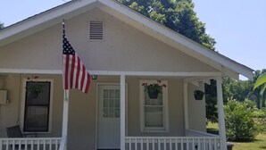 Et hus med veranda, et amerikansk flag og plantekasser.