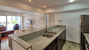 A modern kitchen with granite countertops, stainless steel sinks, and a built-in refrigerator. - Beutifull 2 bedroom apartment in the center of Miraflores! Great Location (Miraflores)