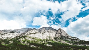 Paesaggio montano con cime rocciose e cielo sereno.