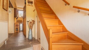 A wooden staircase with a handrail, leading to a landing with a radiator and a metal bucket. - Tranquil Home in Tinlot (Tinlot)