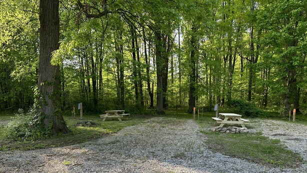 A campground with picnic tables and a gravel path. - Prairie House RV Spaces (Deerfield)