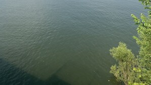 A calm lake with a small boat and a distant shoreline. - Prairie House RV Spaces (Deerfield)