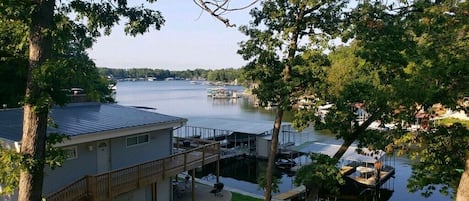 Une propriété au bord du lac, dotée d’un quai, d’un espace extérieur aménagé et couvert, et d’un bâtiment avec une terrasse.