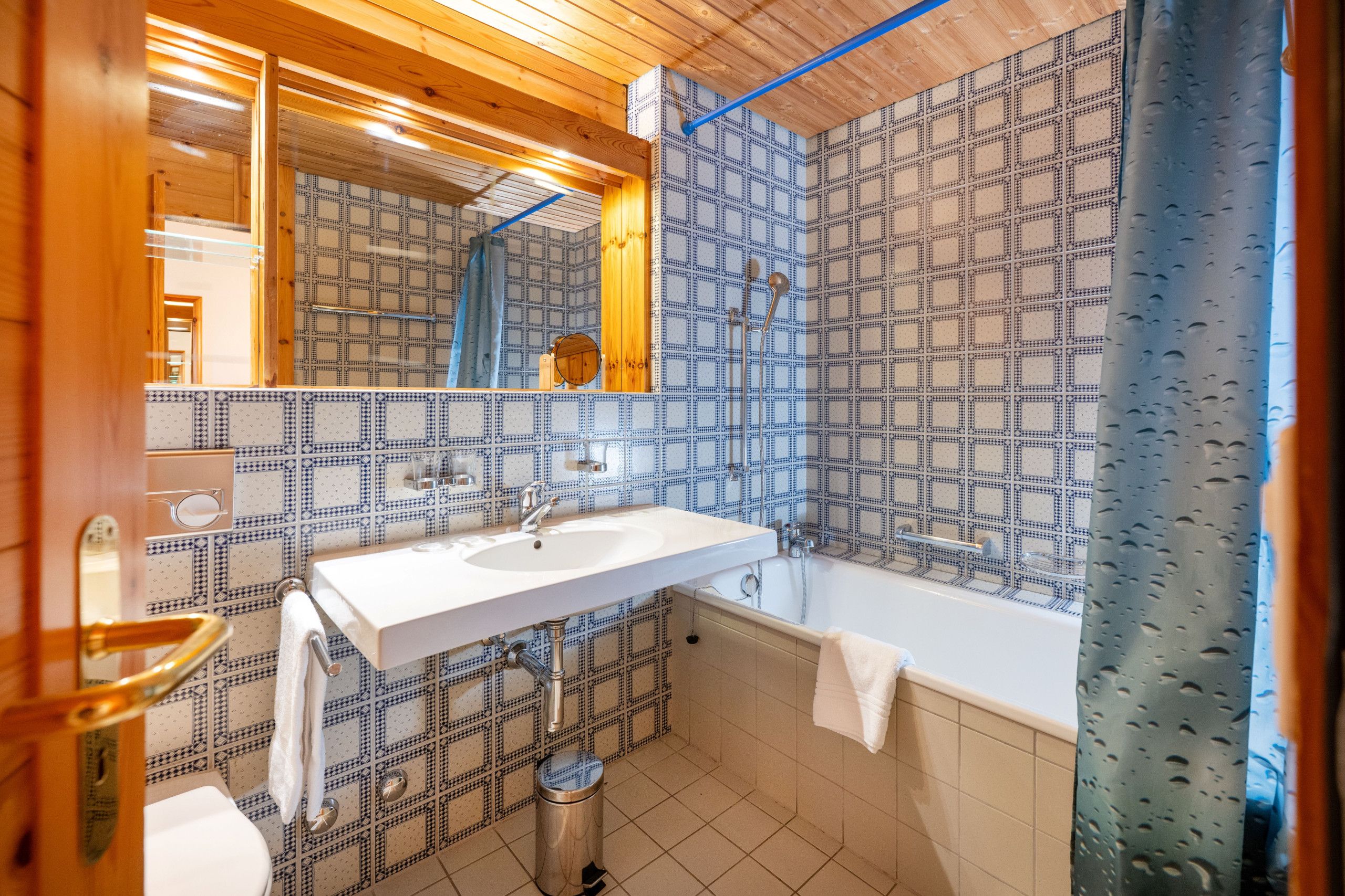 Ein Badezimmer mit weißem Waschbecken, einem Spiegel, einer Badewanne und einer Dusche.