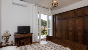 A bedroom with a bed, a television, a desk, and a wardrobe. - Begovic Guest House - Two-bedroom Suite With Balcony (Dubrovnik)