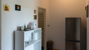 A compact kitchen with a refrigerator, a coffee maker, and a small trash bin. - Begovic Guest House - Two-bedroom Suite With Balcony (Dubrovnik)