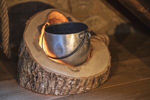 A metal pot on a wooden log with a fire underneath. - Malga Laben (Velo Veronese)