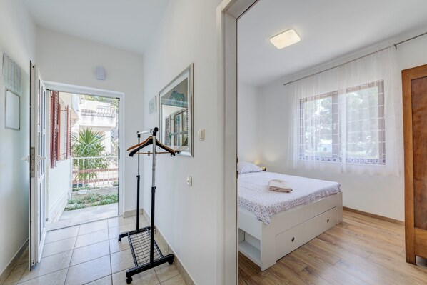 A bedroom with a bed, a mirror, and a door leading to a balcony.