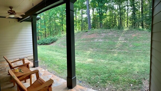 A covered patio with stone flooring and wooden furniture. - HORSE FARM ON PRIVATE 22 ACRES + TROUT POND (Canton)