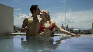 Een koppel in een jacuzzi met een stadsbeeld achter hen.