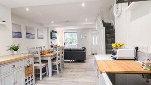 A modern kitchen with a wooden countertop, white cabinetry, and a built-in oven. - 4 Railway Terrace (Conwy)