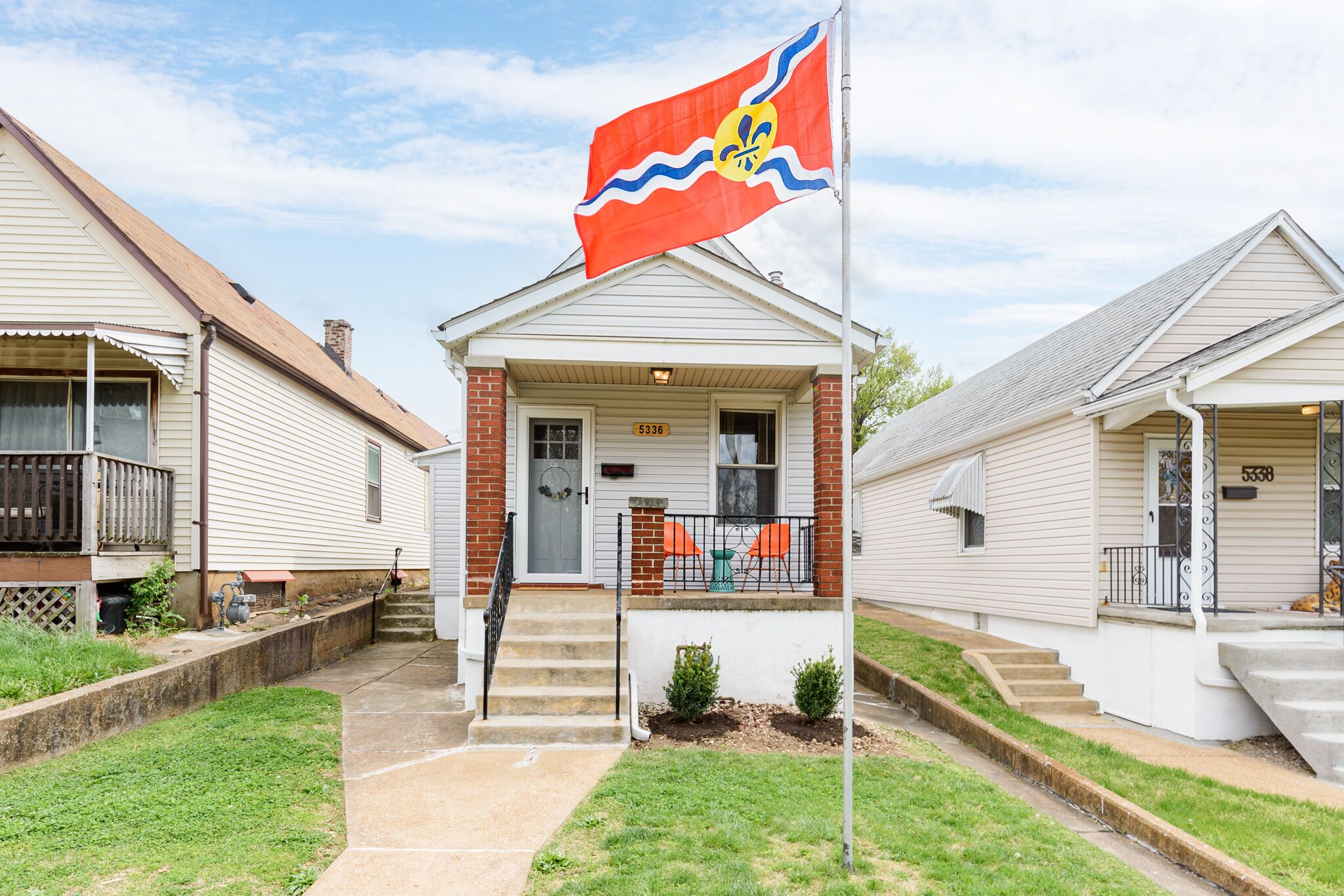 A row of single-story houses with a central flagpole.
